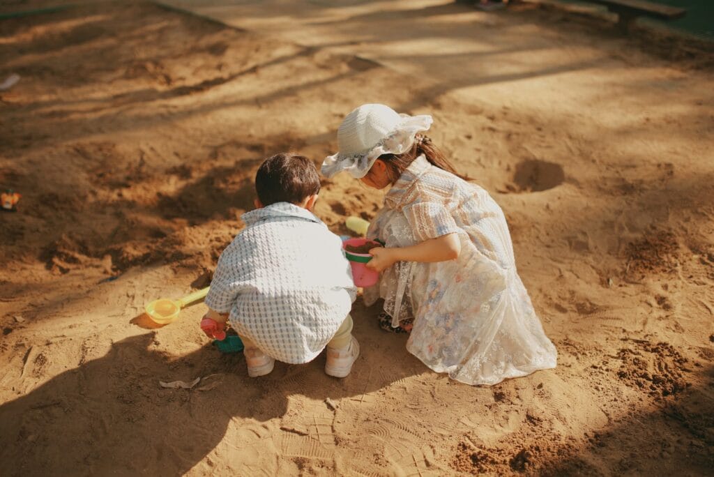 Children play together in a sandbox.